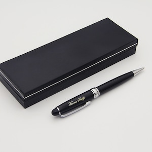 May include: A black pen with a silver trim and the name "Tiana Swift" engraved on it. The pen is in a black box with a silver trim.