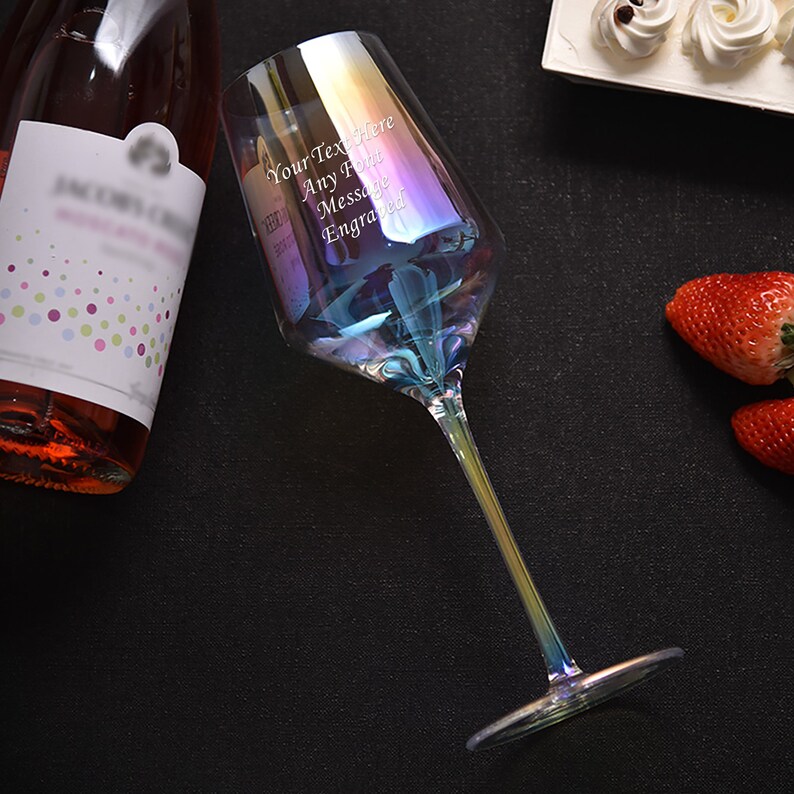 May include: A clear iridescent wine glass with a long stem and a wide bowl. The glass has an inscription that reads "Your Text Here Any Font Message Engraved".