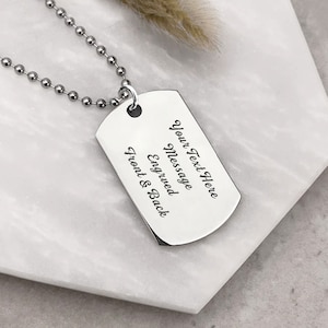 K&ouml;nnte beinhalten: Silberne Hundemarke Halskette mit einer silbernen Kette. Die Hundemarke hat den Text "Your Text Here Message Engraved Front & Back" darauf.
