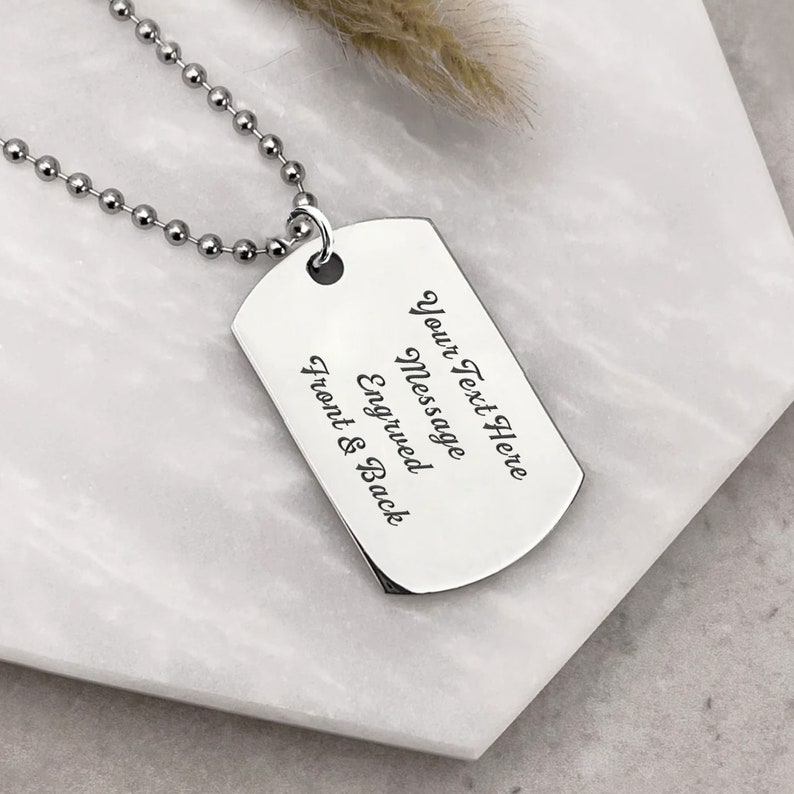 K&ouml;nnte beinhalten: Silberne Hundemarke Halskette mit einer silbernen Kette. Die Hundemarke hat den Text "Your Text Here Message Engraved Front & Back" darauf.