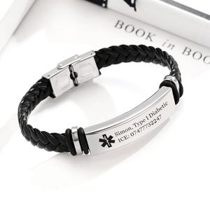 May include: Black braided leather bracelet with a stainless steel plate. The plate is engraved with "Simon, Type 1 Diabetic", an emergency medical symbol, and an ICE phone number. The bracelet has a stainless steel clasp.
