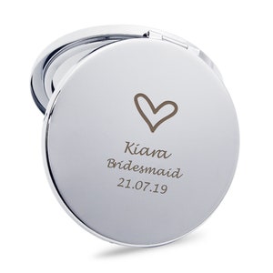 May include: A silver compact mirror with a heart and the text "Kiana Bridesmaid 21.07.19" engraved on the front.