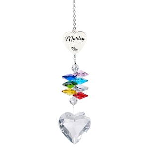 Puede incluir: Un atrapasoles de cristal en forma de coraz&oacute;n con el nombre "Marley" grabado en un colgante de coraz&oacute;n plateado. El atrapasoles presenta una cadena, detalles de cristal de colores y un gran cristal en forma de coraz&oacute;n en la parte inferior.