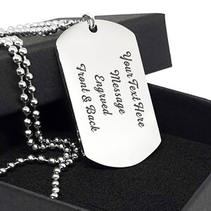 K&ouml;nnte beinhalten: Eine silberne Hundemarke mit einer Kugelkette. Die Hundemarke ist mit dem Text "Your Text Here Message Engraved Front & Back" graviert.