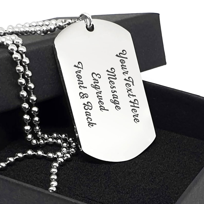 K&ouml;nnte beinhalten: Eine silberne Hundemarke mit einer Kugelkette. Die Hundemarke ist mit dem Text "Your Text Here Message Engraved Front & Back" graviert.