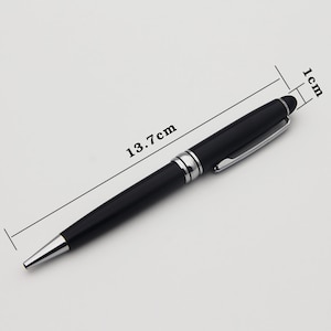May include: A black and silver pen with a clip. The pen is 13.7 cm long and 1 cm wide.
