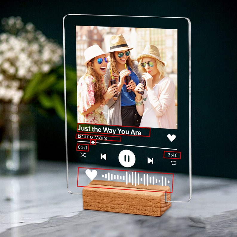 May include: A clear acrylic plaque with a photo of three women, the song title "Just the Way You Are" by Bruno Mars, and a wooden base. The plaque resembles a music player interface.