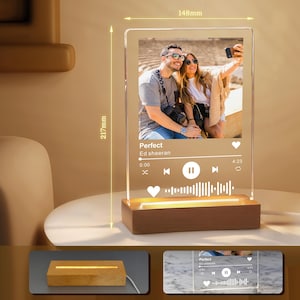 May include: A personalized acrylic photo night light with a wooden base. The light features a photo of a couple and a music player interface with the song title "Perfect" by Ed Sheeran. The acrylic panel measures 217mm high and 148mm wide.