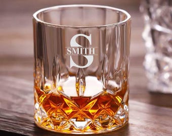 May include: A clear glass whisky tumbler with a diamond-shaped pattern. The glass is filled with amber liquid and has the letter "S" and the word "SMITH" etched on the front.
