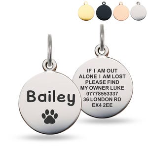 May include: Two circular pet ID tags. One is engraved with the name "Bailey" and a paw print. The other tag has the text "If I am out alone I am lost, please find my owner Luke, 07778553337, 36 London Rd, EX4 2EE."