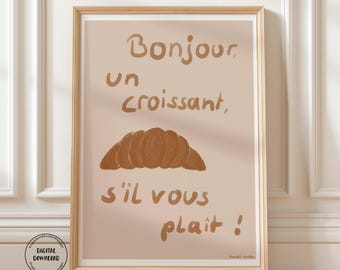 May include: Framed art print featuring a brown croissant illustration and the French text "Bonjour un croissant, s'il vous plaît!" on a beige background. The print is in a wooden frame.