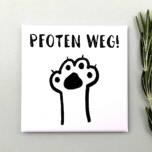 Könnte beinhalten: Quadratischer weißer Leinwanddruck mit dem deutschen Text "PFOTEN WEG!" über einer schwarzen Pfotenabdruck-Illustration. Der Pfotenabdruck hat sichtbare Krallen. Ein Zweig grünen Rosmarins ist im Hintergrund zu sehen.