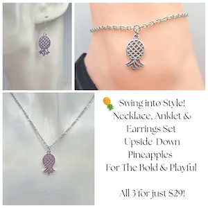 May include: A silver-toned jewelry set featuring upside-down pineapple pendants. The set includes a necklace, anklet, and earrings. The image also includes the text "Swing into Style! Necklace, Anklet & Earrings Set Upside-Down Pineapples For The Bold & Playful".