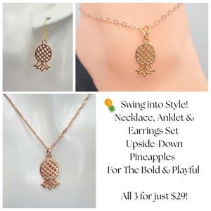 May include: A gold-coloured jewellery set comprising a necklace, anklet, and earrings, each with a pineapple charm. The earrings are dangling, the anklet is around an ankle, and the necklace is on a chain.