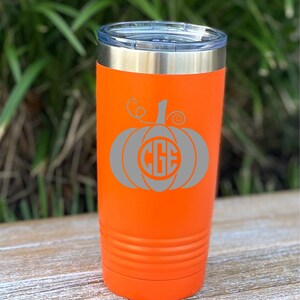 Puede incluir: Un vaso de acero inoxidable naranja con un diseño de calabaza gris y el monograma "CGE".