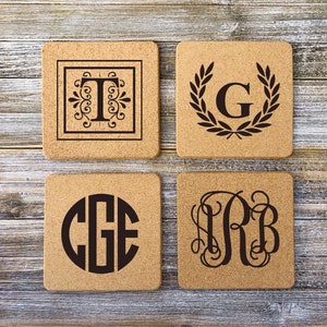 May include: Four cork coasters with different monogram designs. The coasters are square and have a natural cork color. The monograms are in black and include the letters "T", "G", "CGE", and "RB".