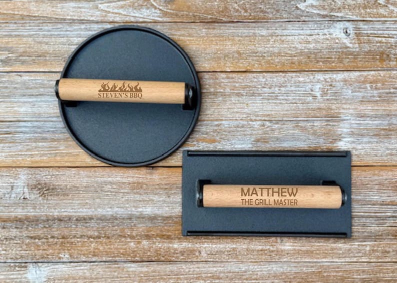 May include: Two black cast iron grill press with wooden handles. The top handle has the text "STEVEN'S BBQ" and flames. The bottom handle has the text "MATTHEW THE GRILL MASTER".