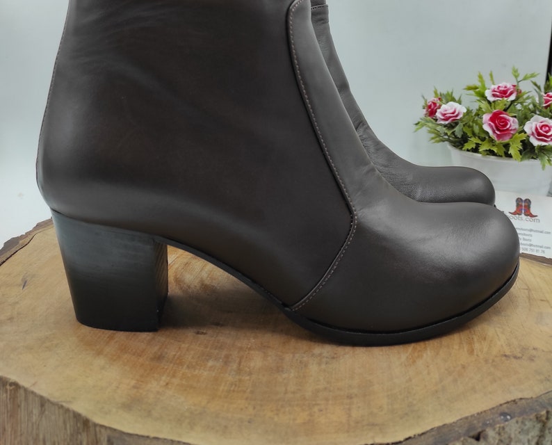 May include: A pair of brown leather heeled ankle boots with a platform toe.