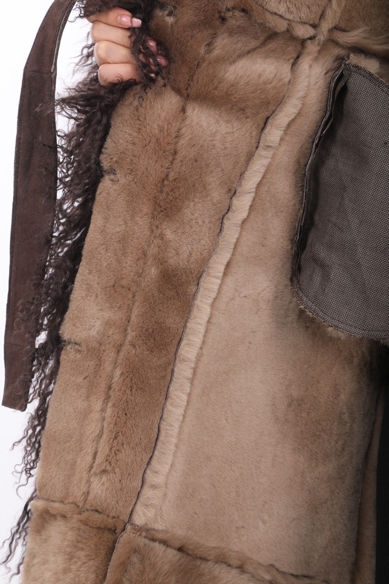 May include: A brown natural fur coat with a suede belt and a brown lining.