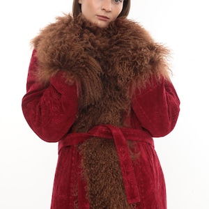 May include: A red coat with a brown fur collar and trim. The coat has a matching belt and a patterned design. The model is wearing the coat against a white background. The coat is a vintage style.