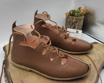 May include: A pair of brown leather sandals with laces that tie up the ankle. The sandals have a cut-out design and a flat sole.