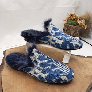 May include: A pair of blue and white patterned slippers with a fuzzy lining. The slippers are made of a soft, plush fabric and have a comfortable fit.