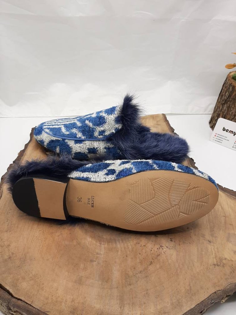 May include: Blue and white patterned slippers with a faux fur trim and a leather sole. The sole is marked "Leather Sole" and "36".