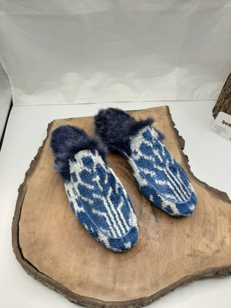 May include: A pair of blue and white patterned slippers with a faux fur trim.
