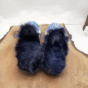 May include: Pair of blue and white patterned slippers with a fluffy black faux fur lining.