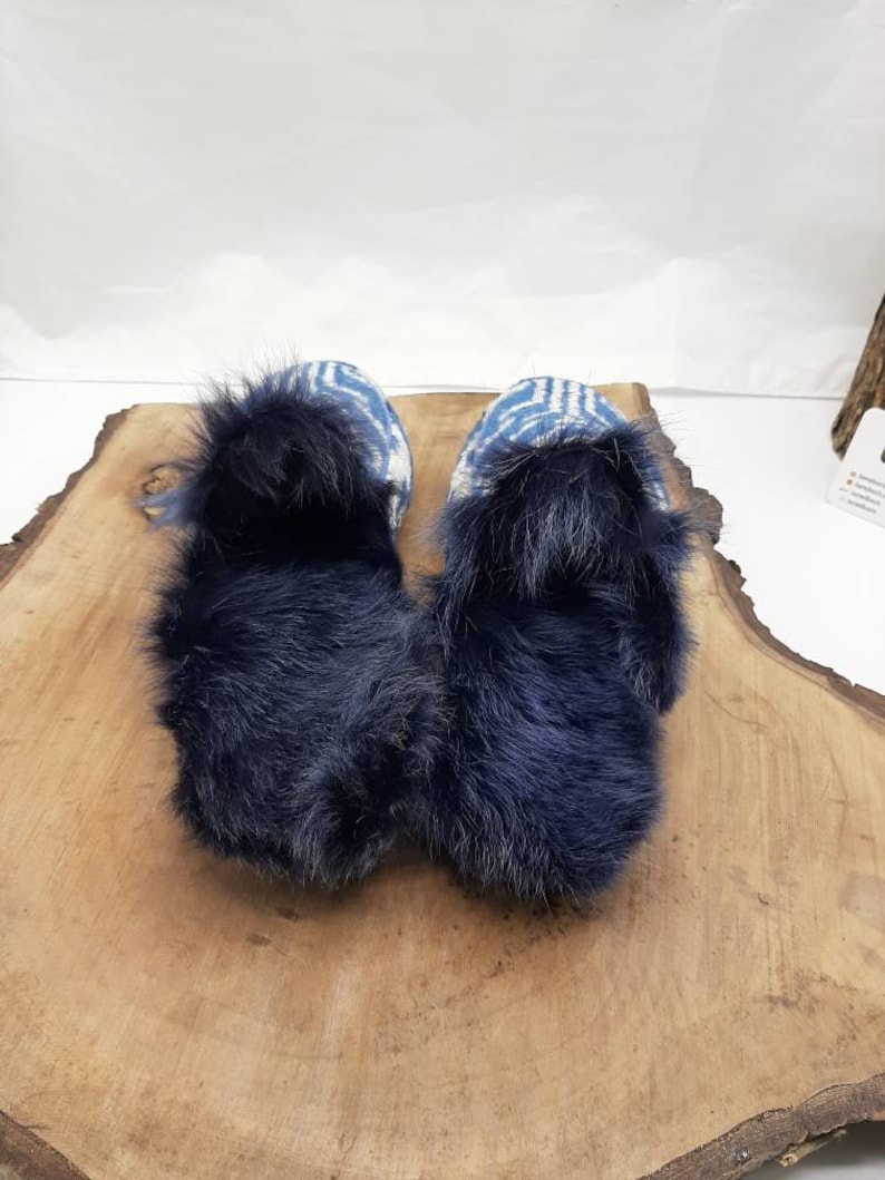 May include: Pair of blue and white patterned slippers with a fluffy black faux fur lining.