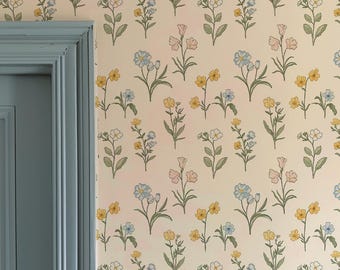 May include: A room interior featuring a light blue door and wainscoting. The wall is covered in floral wallpaper with yellow, blue, and pink flowers on a cream background. The door has a brass door handle.