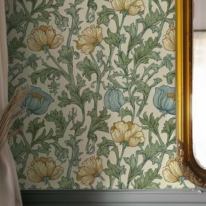 Può includere: Interno di una stanza con carta da parati floreale con fiori gialli e blu e foglie verdi. Uno specchio con cornice dorata riflette una tenda bianca. La parte inferiore del muro è dipinta di grigio chiaro, con pannelli verticali.