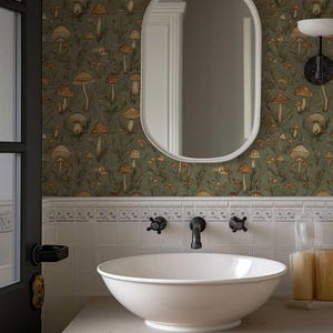 May include: A white porcelain sink with a rounded bowl sits on a white countertop in a bathroom. The bathroom features a green wallpaper with a mushroom pattern and a white oval mirror.
