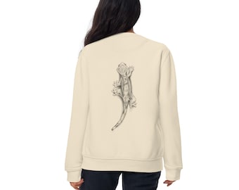 Puede incluir: Sudadera de color crema con una ilustración detallada en blanco y negro de un lagarto en la espalda. El lagarto está representado en un estilo realista, con escamas visibles y una cola larga. La sudadera tiene cuello redondo y mangas largas.