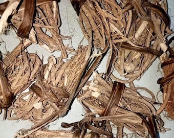 May include: Close-up of several bundles of dried roots and stems, tied together with dark brown strips. The bundles are a mix of light and dark brown, with some dried leaves visible. The background is a light blue-gray.