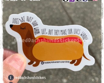 May include: A glossy 2 inch by 3 inch sticker featuring a cartoon dachshund with a hot dog body. The text on the sticker reads "Dogs are not our whole life, but they make our lives whole."