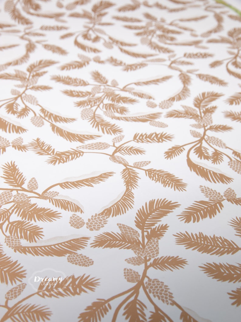 May include: A white background with a repeating pattern of brown pine branches and pine cones. The pattern is a simple, elegant design.
