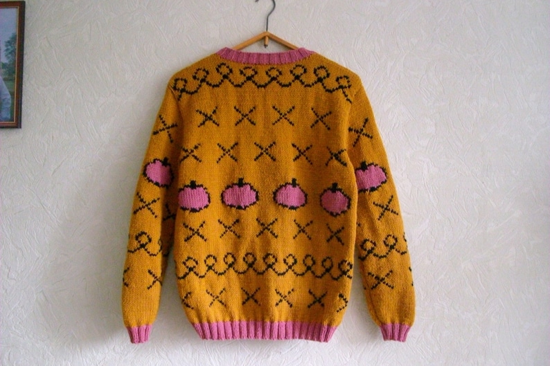 This listing is for a hand knit sweater inspired by Bojack Horseman animated cartoon. It features four pink apples on mustard background across the chest area with corresponding pattern on the back, sleeves. Knitted of half wool half acrylic blend.