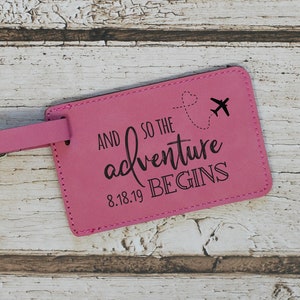 May include: Pink leather luggage tag with a black airplane graphic and the text "And so the adventure begins 8.18.19"