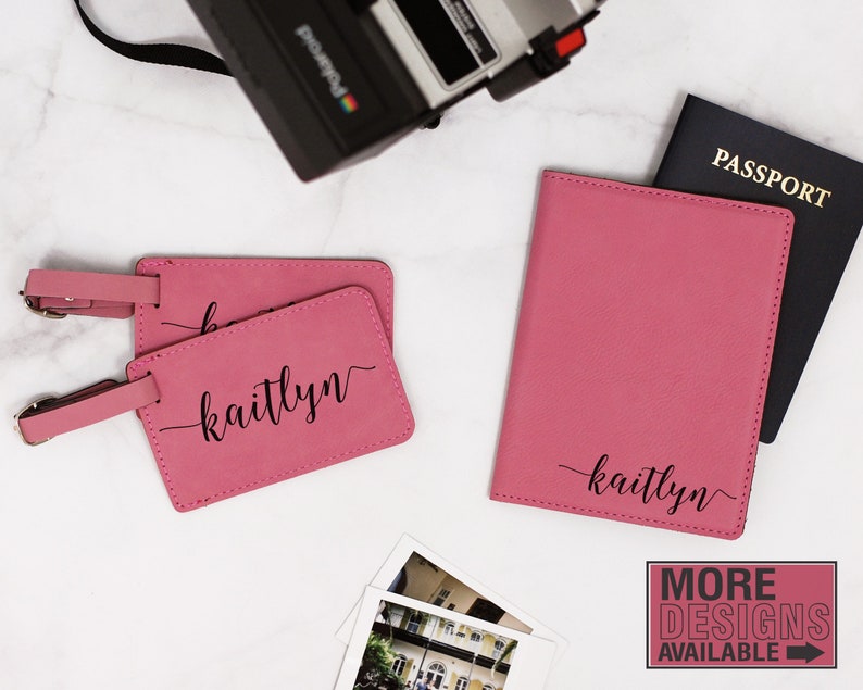 May include: Two pink leather luggage tags with the name "kaitlyn" written in black cursive. A pink leather passport holder with the same name is also shown. The items are on a white marble surface.