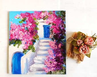 May include: A painting of a white building with a blue door and steps, surrounded by pink flowers. The building is set against a blue sky.