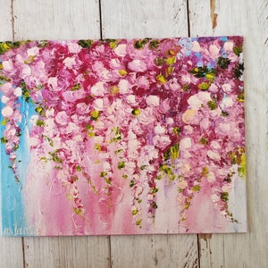 K&ouml;nnte beinhalten: Ein Gem&auml;lde einer rosafarbenen und gr&uuml;nen Glyzinien-Bl&uuml;tenkaskade. Die Bl&uuml;ten sind in einem lockeren, impressionistischen Stil gemalt, mit sichtbaren Pinselstrichen. Der Hintergrund ist ein sanftes Blau und Rosa.