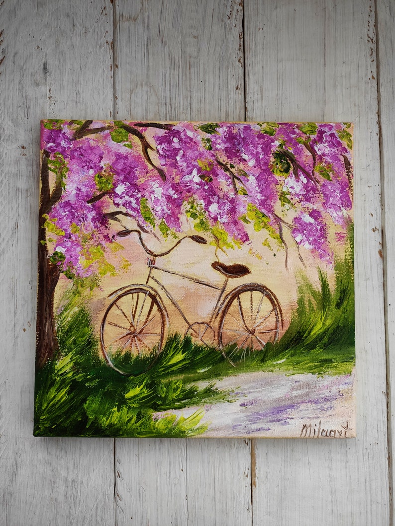 May include: A painting of a bicycle parked under a tree with purple flowers. The bicycle is brown with a brown seat and black tires. The background is a light yellow with green grass and a white path.