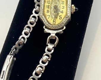 Vintage Art Deco ladies' wristwatch with engraved bezel and gold-toned dial.