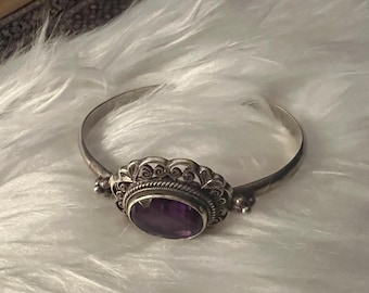 Sterling silver bracelet with oval amethyst and Bali-style scrollwork.