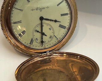 This is an antique Elgin open-face pocket watch.