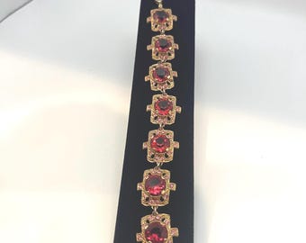 Vintage gold-tone bracelet with large faux ruby and smaller pink stones.
