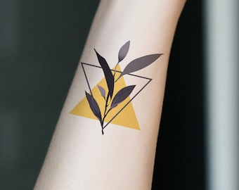May include: A yellow triangle with a black floral design inside. The design is of a branch with leaves.