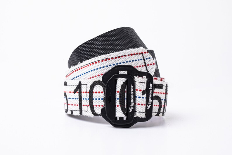 May include: A white and black belt with red and blue stripes and the text "Flybooster" printed on it. The belt has a black buckle.