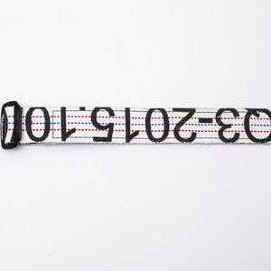 May include: White belt with black text that reads "W-30-2019-10". The belt has red and blue stripes.